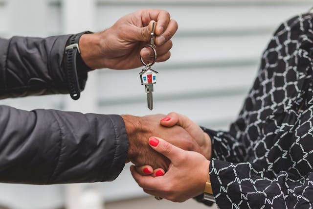 two people shaking hands and engaging house keys after a purchase